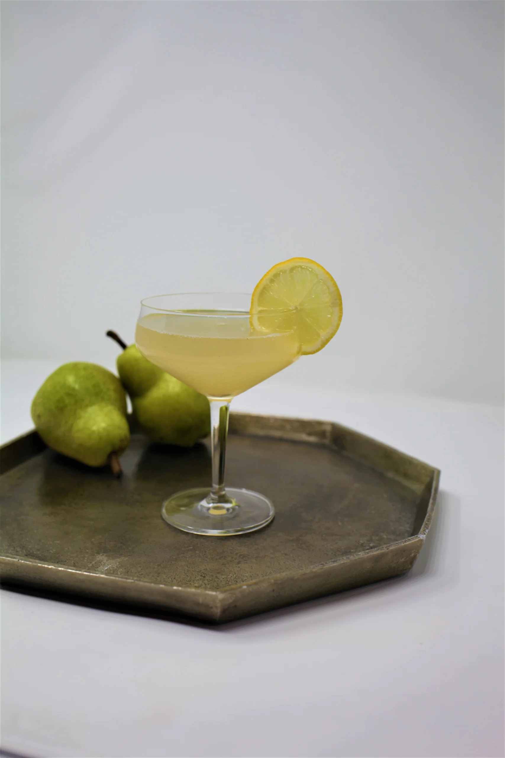 Signature gold cocktail in a coupe at the marble bar